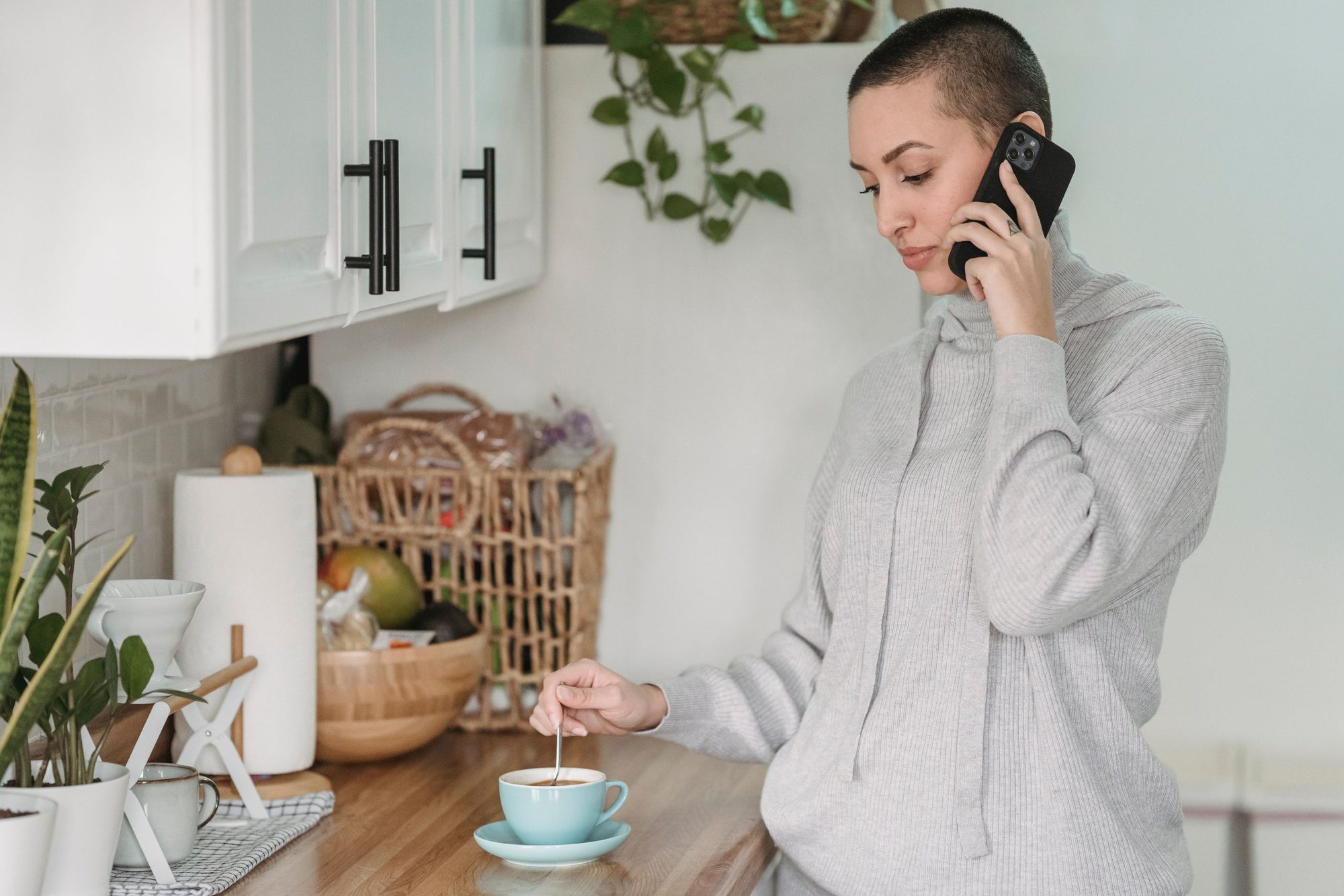 A woman in her kitchen reading the day's summary on her phone