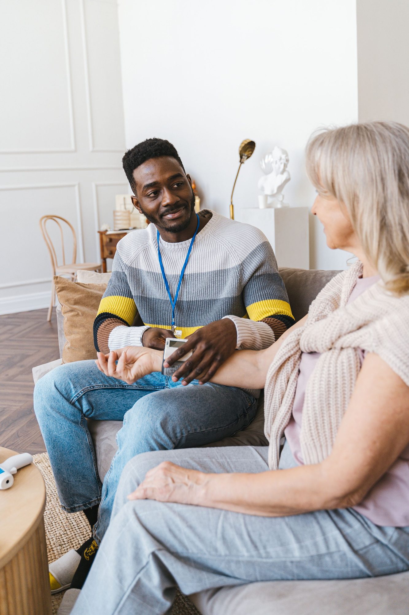 A care worker sitting with an older woman in her living room during a visit