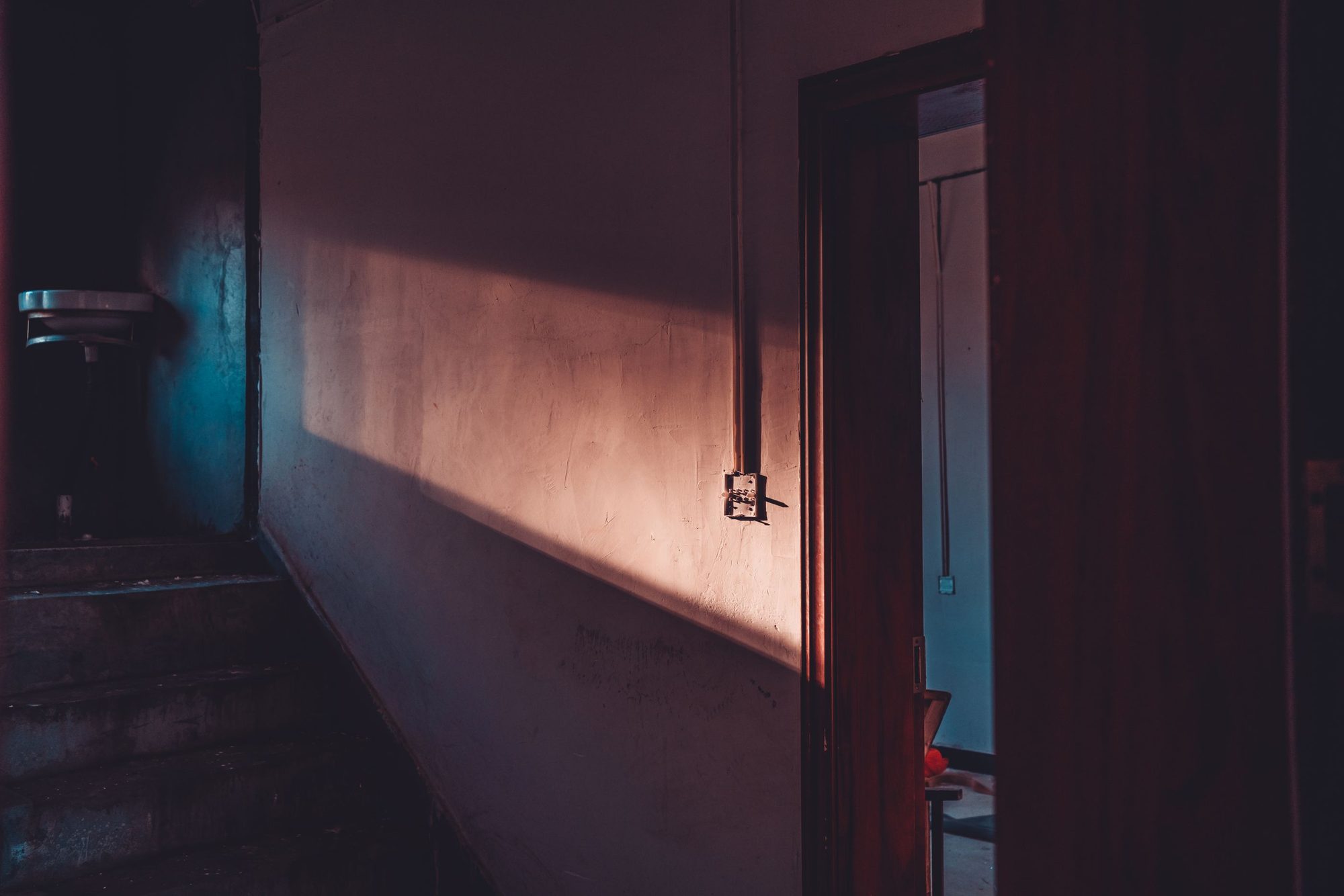 A dim hallway at night with soft warm light across the wall