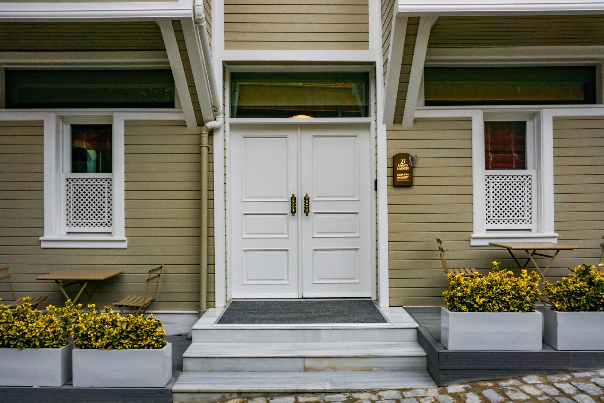 The front porch of a house on a bright afternoon, where a visitor would arrive