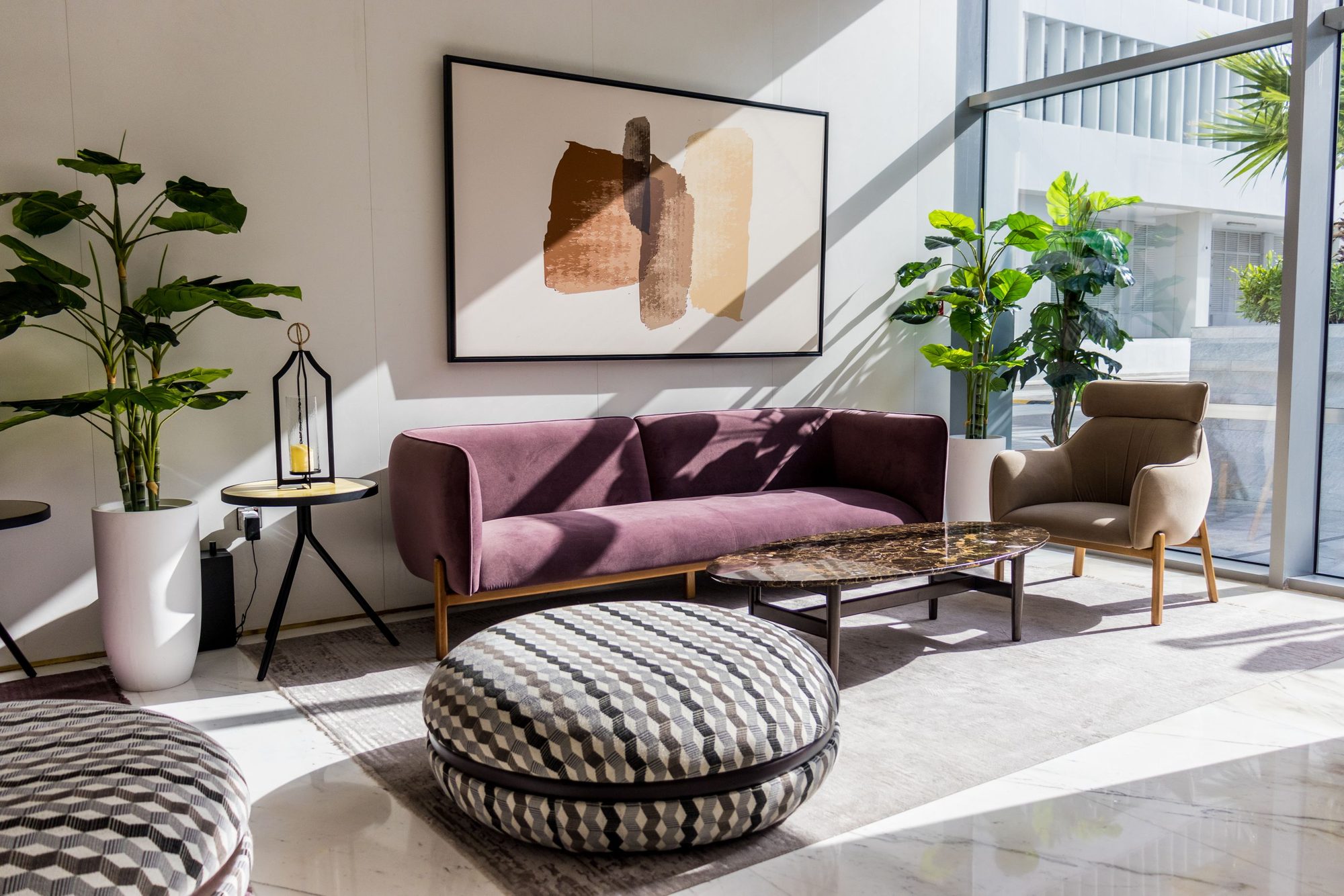 A bright living room with a sofa and armchairs, the kind of shared space a single indoor camera covers
